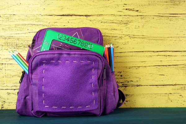 Školní batoh na dřevěné pozadí — Stock fotografie
