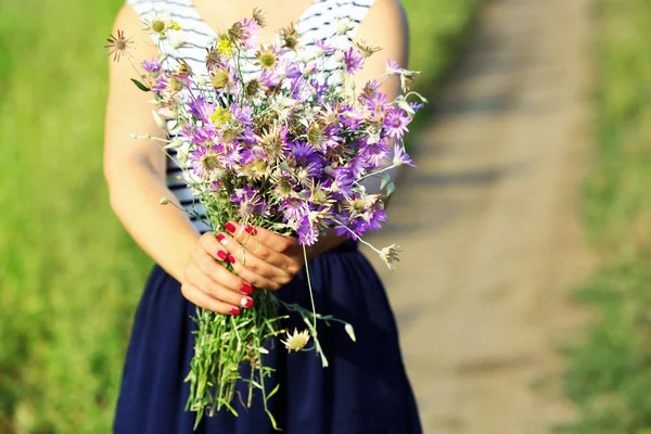 Frauenhände mit Blumenstrauß — Stockfoto