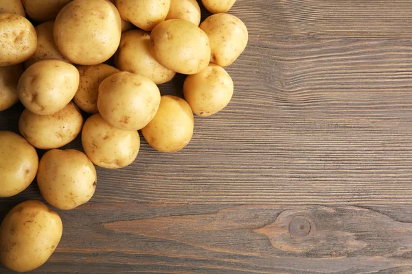 Batatas novas em fundo de madeira — Fotografia de Stock