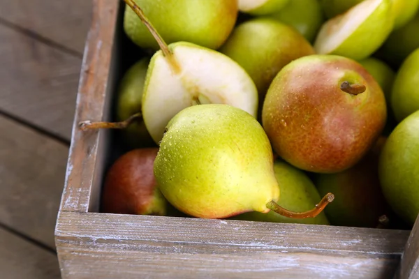 Rijpe peren in houten kist — Stockfoto