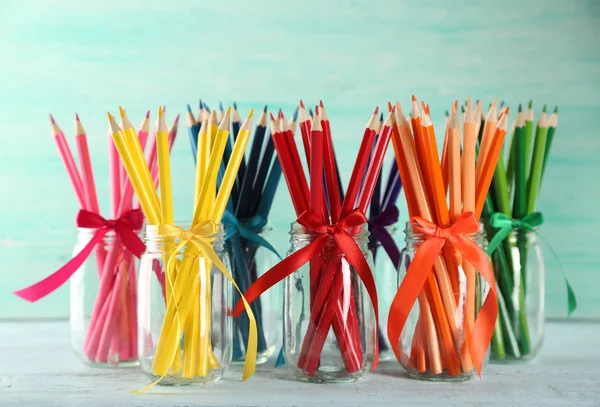 Bright pencils in glass jars — Stock Photo, Image