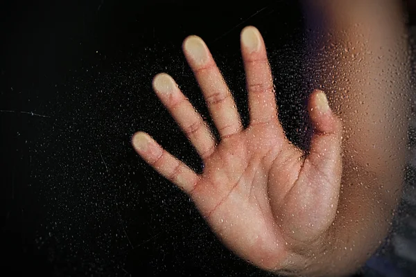 Male hand behind  wet glass — Stock Photo, Image