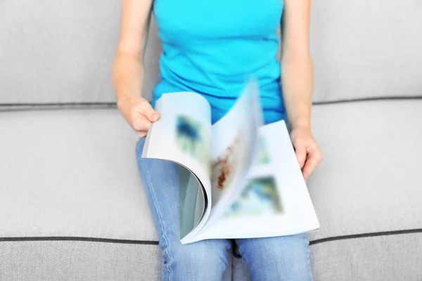 Frau liest Magazin auf Sofa — Stockfoto