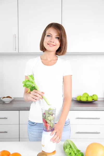 Ung vacker kvinna med mixer, förbereda apelsinjuice — Stockfoto