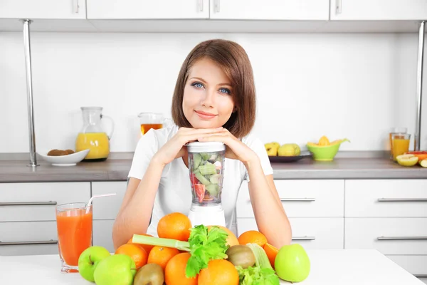 Joven hermosa mujer usando licuadora, preparando jugo de naranja — Foto de Stock