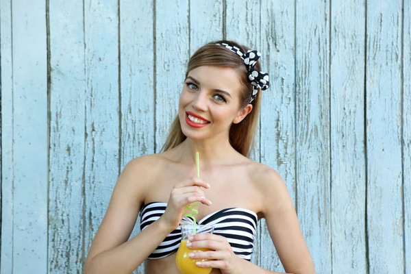 Hermosa chica con bonita sonrisa con cóctel en el fondo de madera de color — Foto de Stock