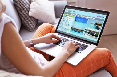 Online kitap otele dizüstü bilgisayar kullanan kadın