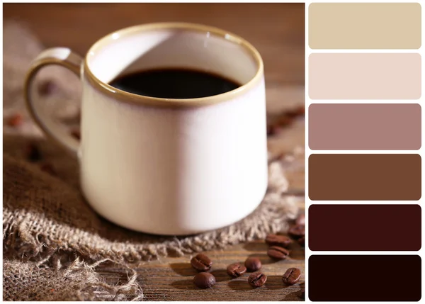 Cup with hot coffee and roasted coffee grains  on wooden table and palette of colors — Stock Photo, Image