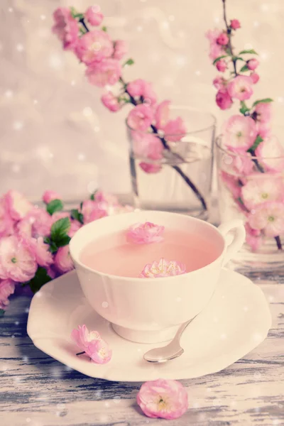 Cup of tea and beautiful fruit blossom on table — Stock Photo, Image