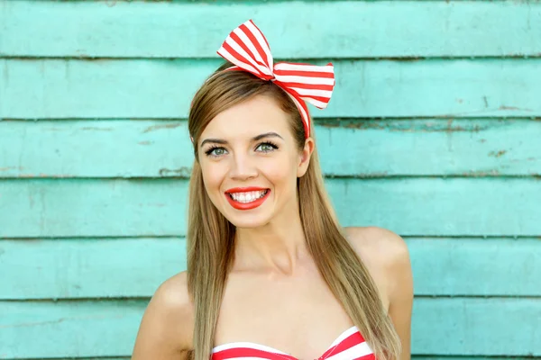 Menina bonita com sorriso bonito na cor de fundo de madeira — Fotografia de Stock