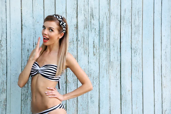 Menina bonita com sorriso bonito na cor de fundo de madeira — Fotografia de Stock