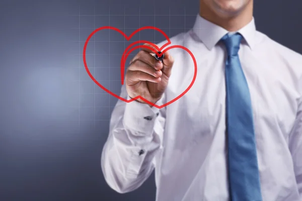Man drawing heart on grey background — Stock Photo, Image