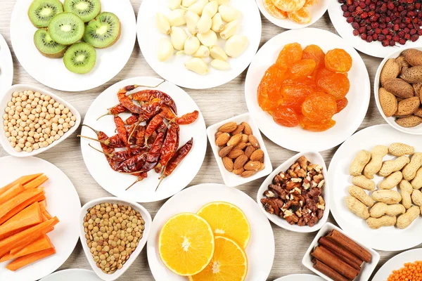 Different products on saucers on wooden table, top view — Stock Photo, Image