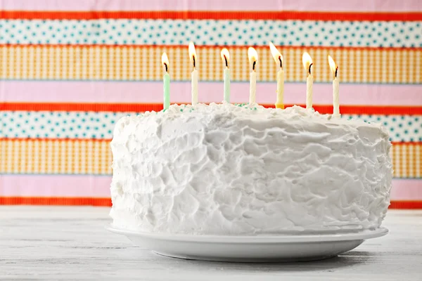 Birthday cake with candles on colorful striped background — Stock Photo, Image