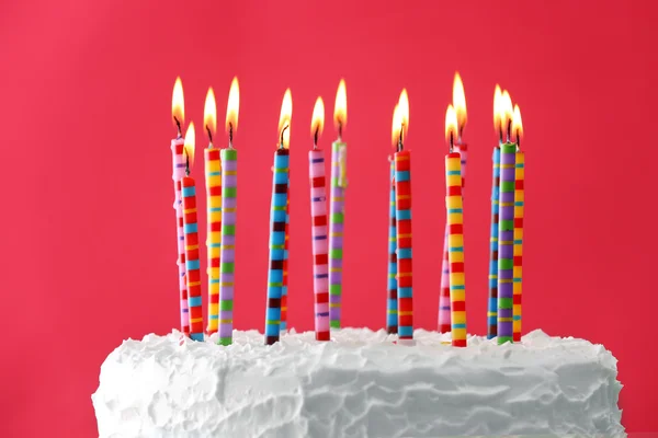 色の背景にろうそく付きの誕生日ケーキ — ストック写真