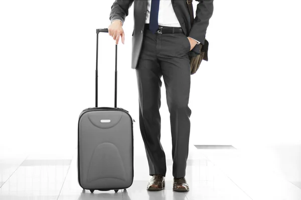Mann mit Koffer auf hellem Hintergrund — Stockfoto