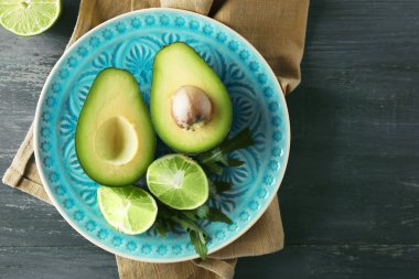 avokado ve limon kireç ahşap arka plan üzerine dilimlenmiş