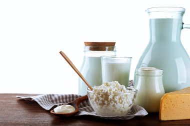 Beyaz arka plan üzerinde ahşap masa üzerinde süt ürünleri