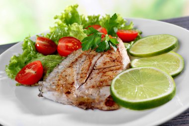 Balık fileto salata ve kireç plaka üzerinde tabak kapat