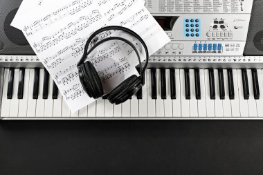 Headphones with music notes on synthesizer close up clipart