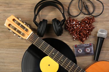 Klasik Gitar, vinil kayıt, mikrofon, kaset ve ahşap arka plan üzerinde kulaklık ile müzik kayıt sahne