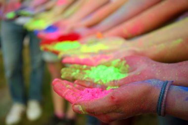 Hands of young people with Indian dyes on Holi color festival clipart