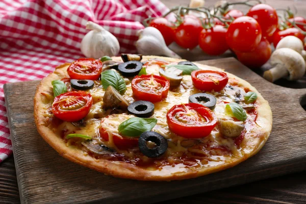 Gustosa pizza con verdure e basilico in tavola da vicino — Foto Stock