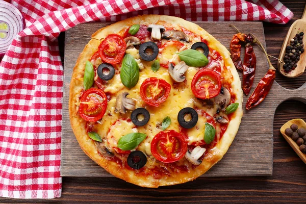 Tasty pizza with vegetables and basil on table close up — Stock Photo, Image