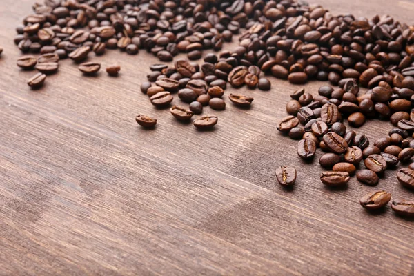 Granos de café sobre fondo de madera —  Fotos de Stock