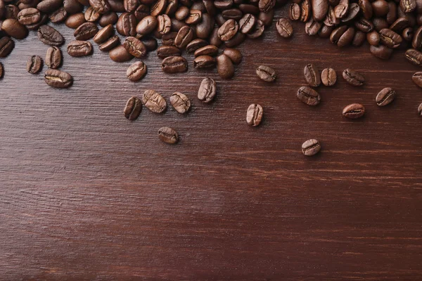 Grãos de café em fundo de madeira — Fotografia de Stock