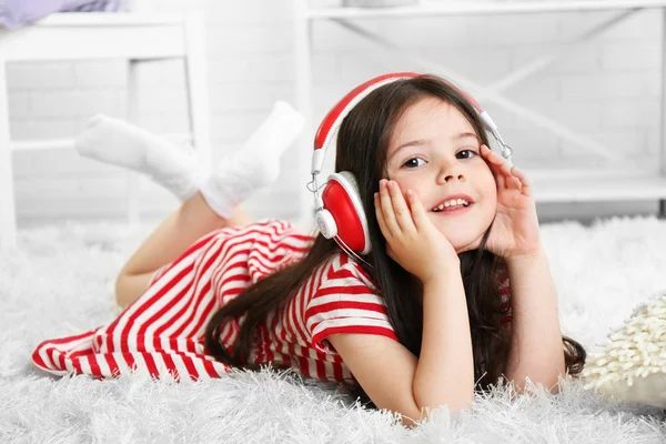 Vacker liten flicka lyssna på musik i rummet — Stockfoto