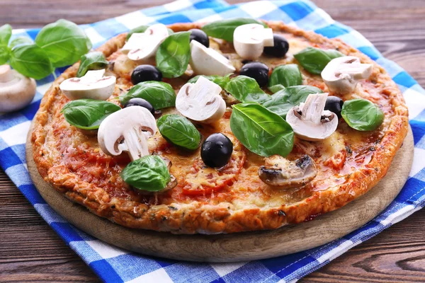 Gustosa pizza con verdure e basilico in tavola da vicino — Foto Stock