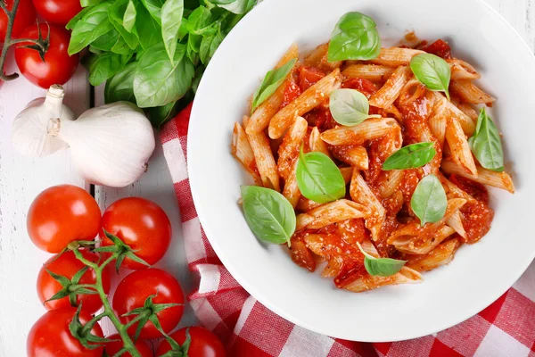 Pasta med tomatsås och basilika på bordet på nära håll — Stockfoto