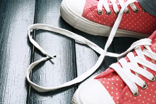 Pies femeninos en zapatos de goma sobre fondo de madera de color —  Fotos de Stock