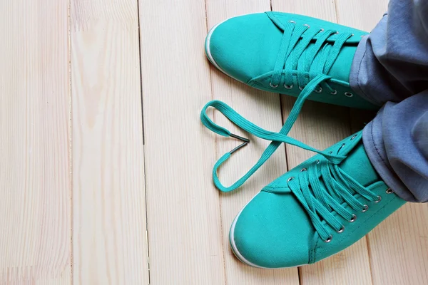 Female feet in gum shoes on wooden floor background — Stock Photo, Image