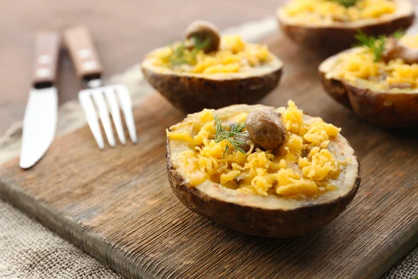 Batatas assadas com queijo e cogumelos na mesa de perto — Fotografia de Stock