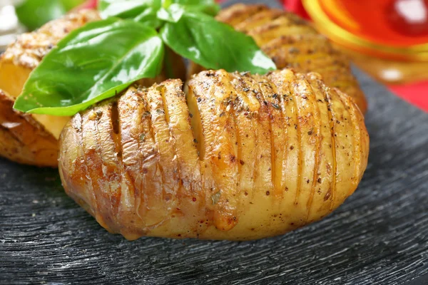 Patatas al horno con hojas de albahaca, primer plano —  Fotos de Stock