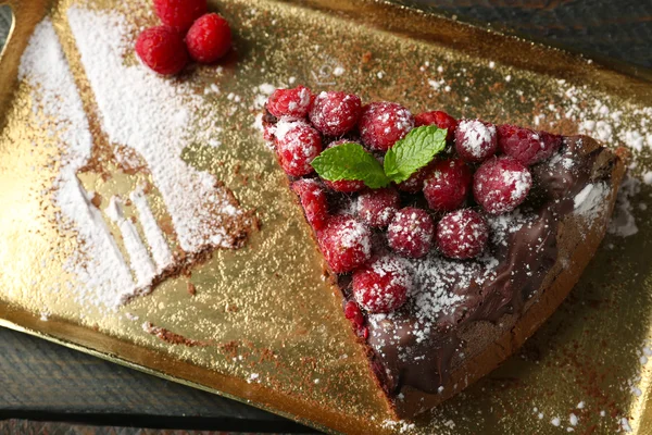 Kuchen mit Schokoglasur und Himbeeren auf Blech auf Holzgrund — Stockfoto