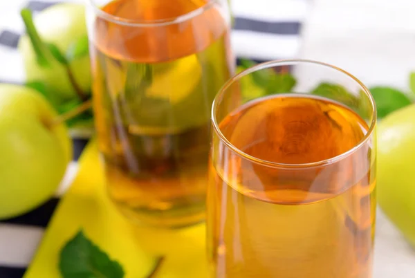 Glasses of apple juice with fruits and fresh mint on table close up — Stock Photo, Image