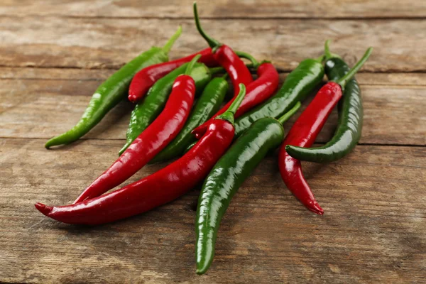 Hot peppers on wooden table close up — Stock Photo, Image