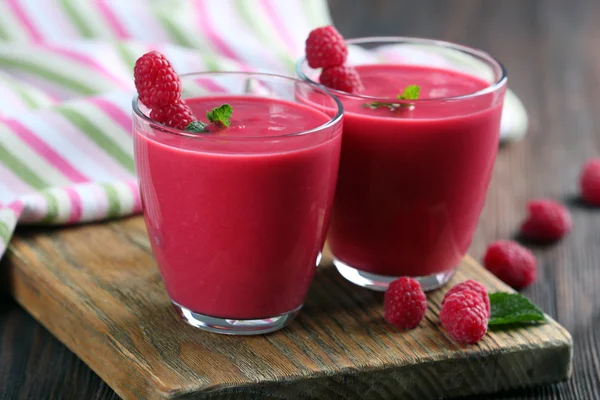 Ahşap masa üzerinde çilek ile Ahududu milkshake bardak yakın çekim