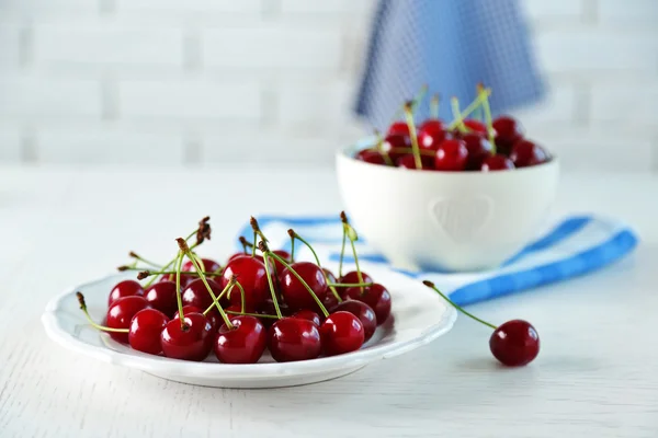 Sweet cherries on plate, on light background — Stock Photo, Image