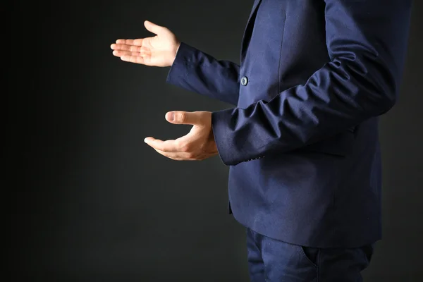 Businessman in suit introduce something on dark background — Stock Photo, Image