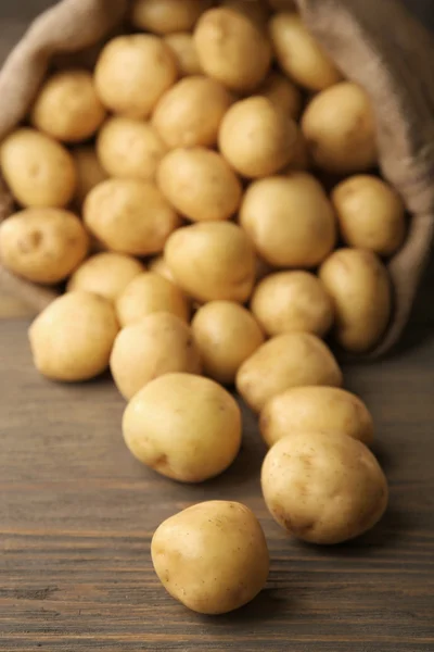 Nieuwe aardappelen op houten tafel, close-up — Stockfoto