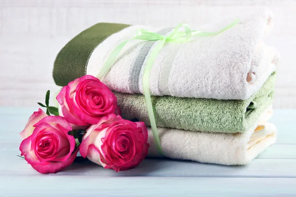 Stack of colorful towels on light wooden background — Stock Photo, Image
