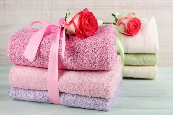 Hafif ahşap arka plan üzerinde renkli havlu yığını