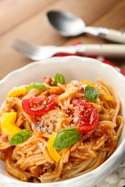 Spaghetti Bolognais maison au parmesan dans un bol blanc, sur fond de bois de couleur — Photo