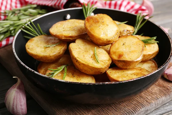 Delicious baked potato with rosemary in frying pan on table close up — Stock Photo, Image