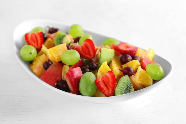 Verse fruitsalade op witte houten tafel — Stockfoto