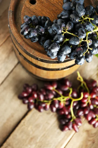 Barrica de vino viejo y uva sobre fondo de madera — Foto de Stock